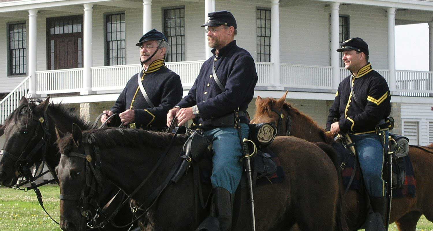 Civil War re-enactors ride their horses