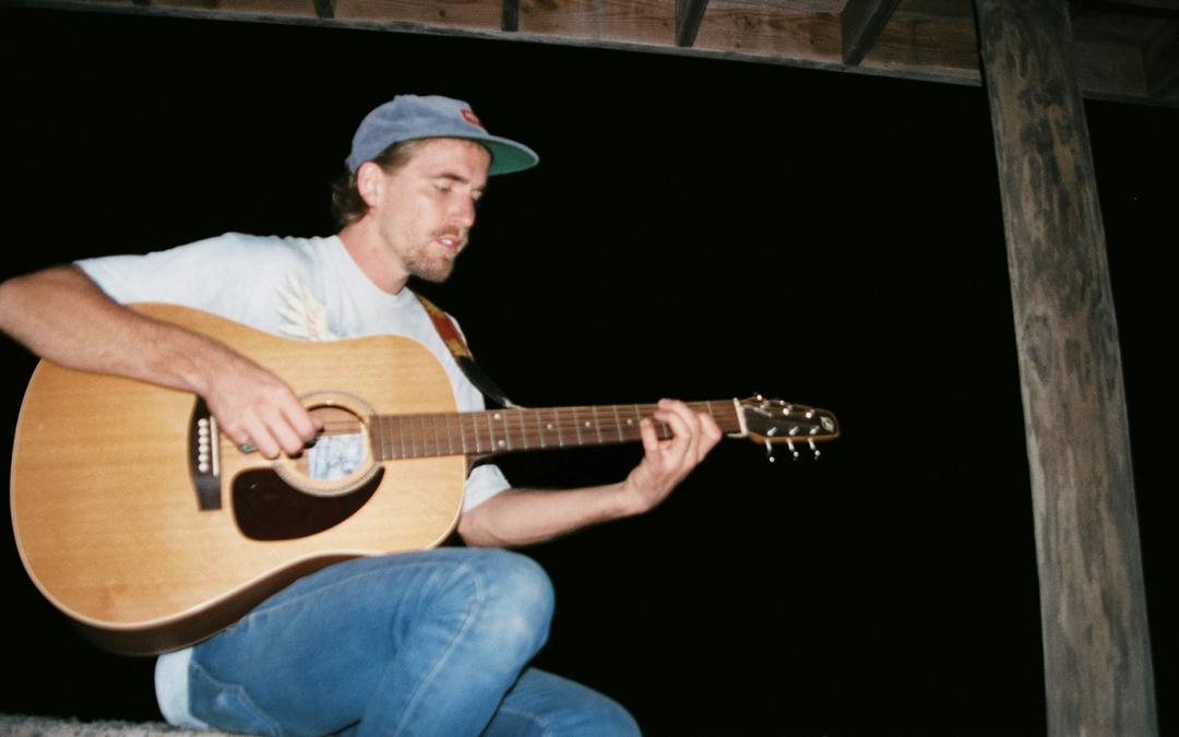 man playing guitar on porch